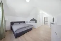 Grosszügiges Schlafzimmer im Dachgeschoss mit Masterbad auf derselben Etage.