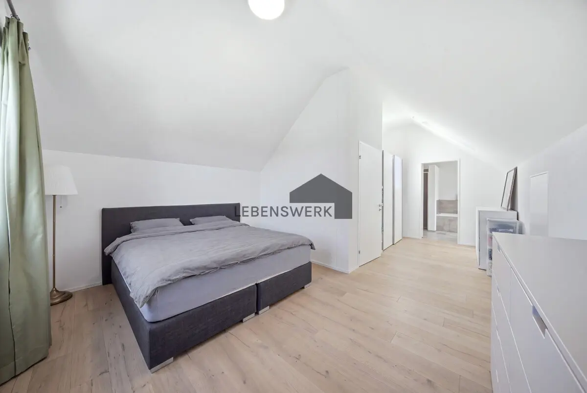 Grosszügiges Schlafzimmer im Dachgeschoss mit Masterbad auf derselben Etage.