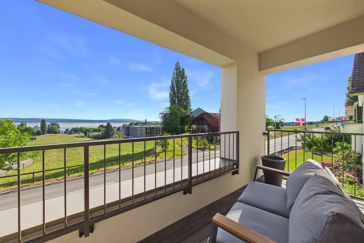 Sonniger, gedeckter Balkon mit schönem Ausblick ins Grüne und auf den Bodensee.