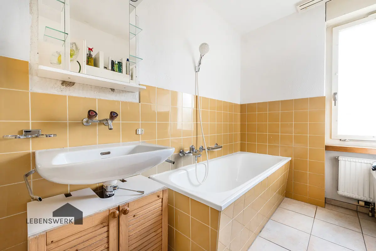 Badezimmer mit Tageslicht, Badewanne und separater Dusche