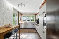 Küche mit viel Stauraum, grossen Fensterflächen und direktem Zugang zum Gartensitzplatz