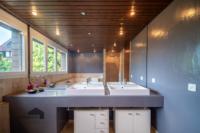 Dieses grosszügige Badezimmer überzeugt mit viel Tageslicht und stilvollen Details