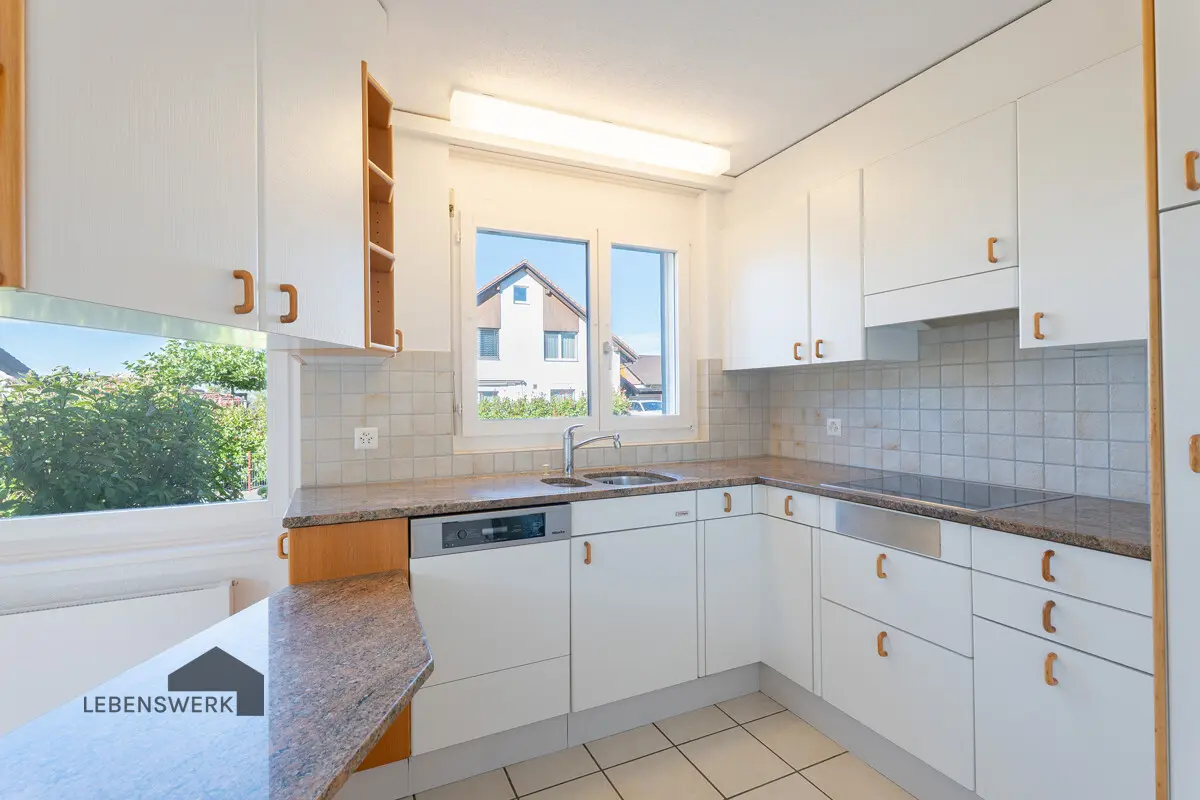 Die helle Küche mit viel Stauraum und praktischer Aufteilung macht Kochen zum Vergnügen