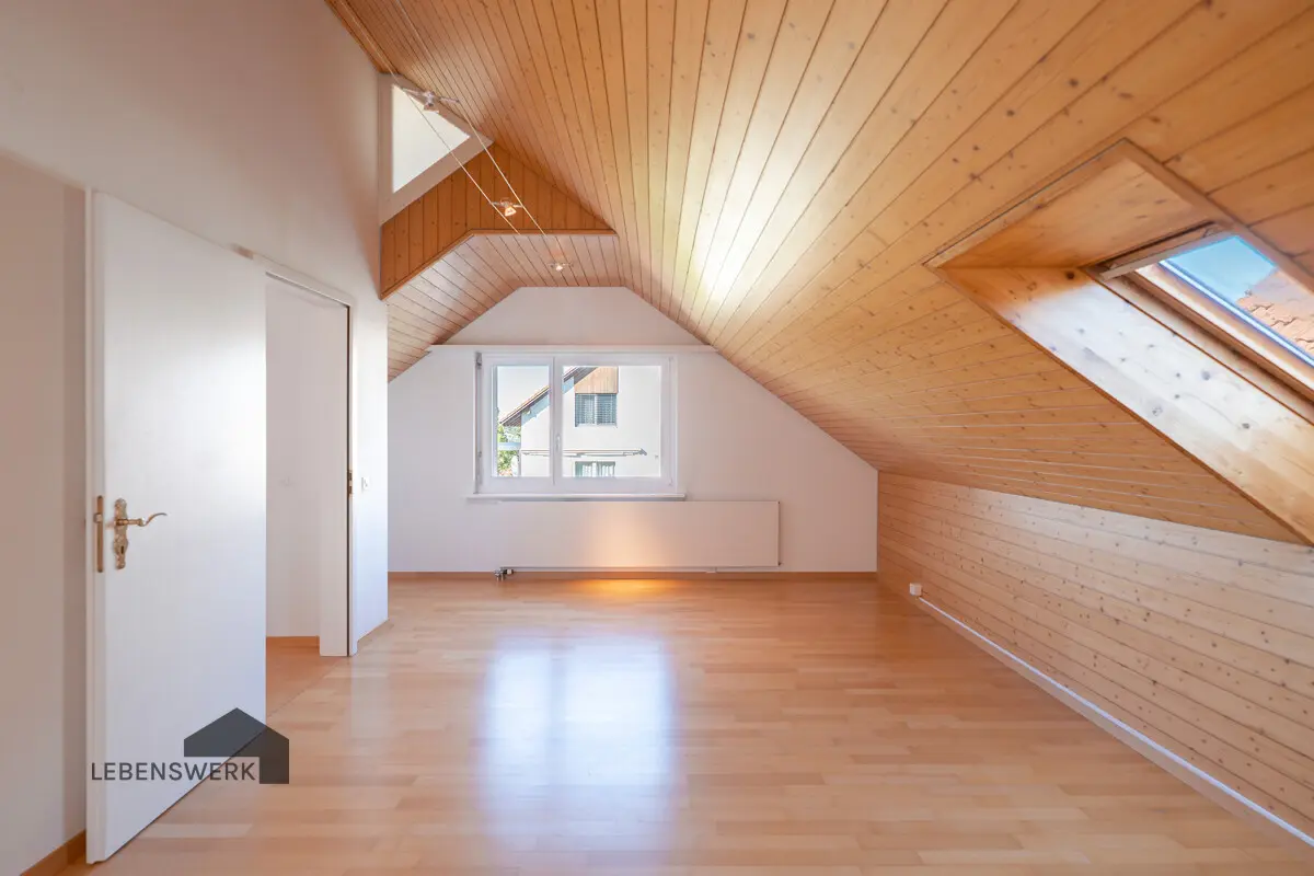 Das charmante Zimmer über der Garage begeistert mit viel Tageslicht und warmer Holzdecke