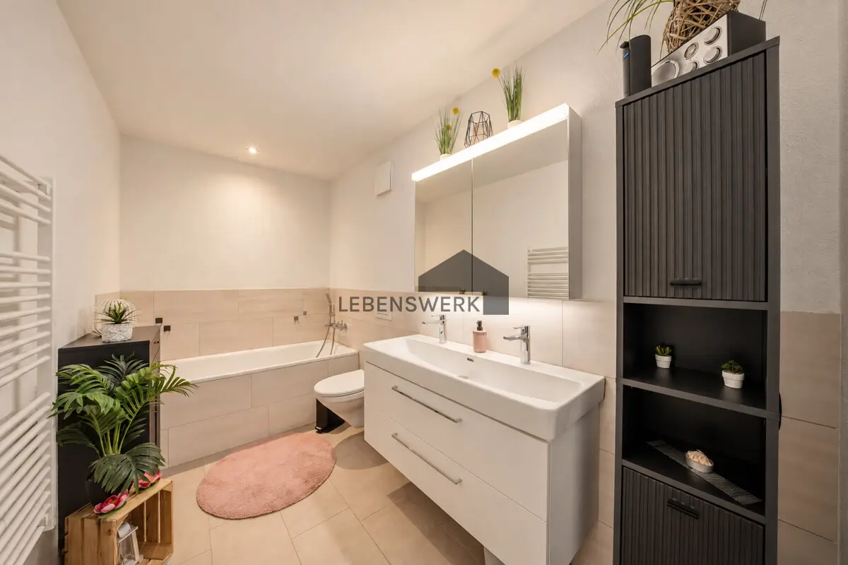 Einladendes Badezimmer mit Badewanne und grosszügigem Waschtisch für entspannte Alltagsmomente.