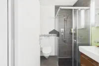 Modernes Badezimmer mit grosszügiger Dusche und hochwertiger, zeitloser Ausstattung.