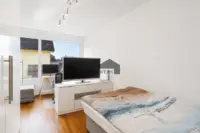 Gemütliches Schlafzimmer mit viel Tageslicht und zusätzlichem Platz für einen kleinen Arbeitsbereich.