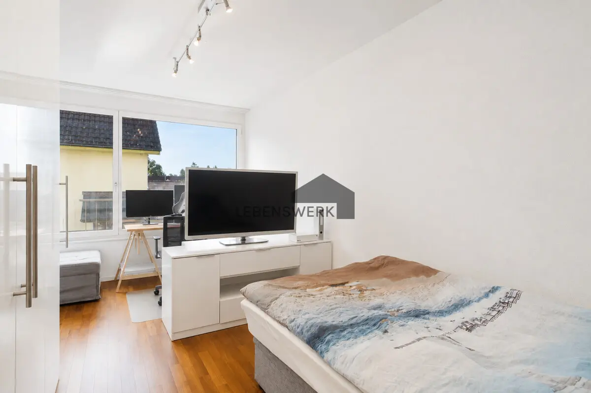 Gemütliches Schlafzimmer mit viel Tageslicht und zusätzlichem Platz für einen kleinen Arbeitsbereich.