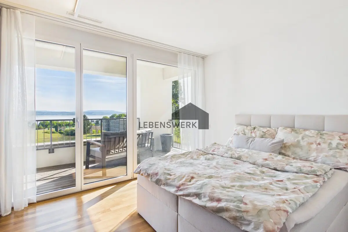 Helles Schlafzimmer mit direktem Balkonzugang sowie Masterbad und traumhaftem Blick auf den Bodensee.