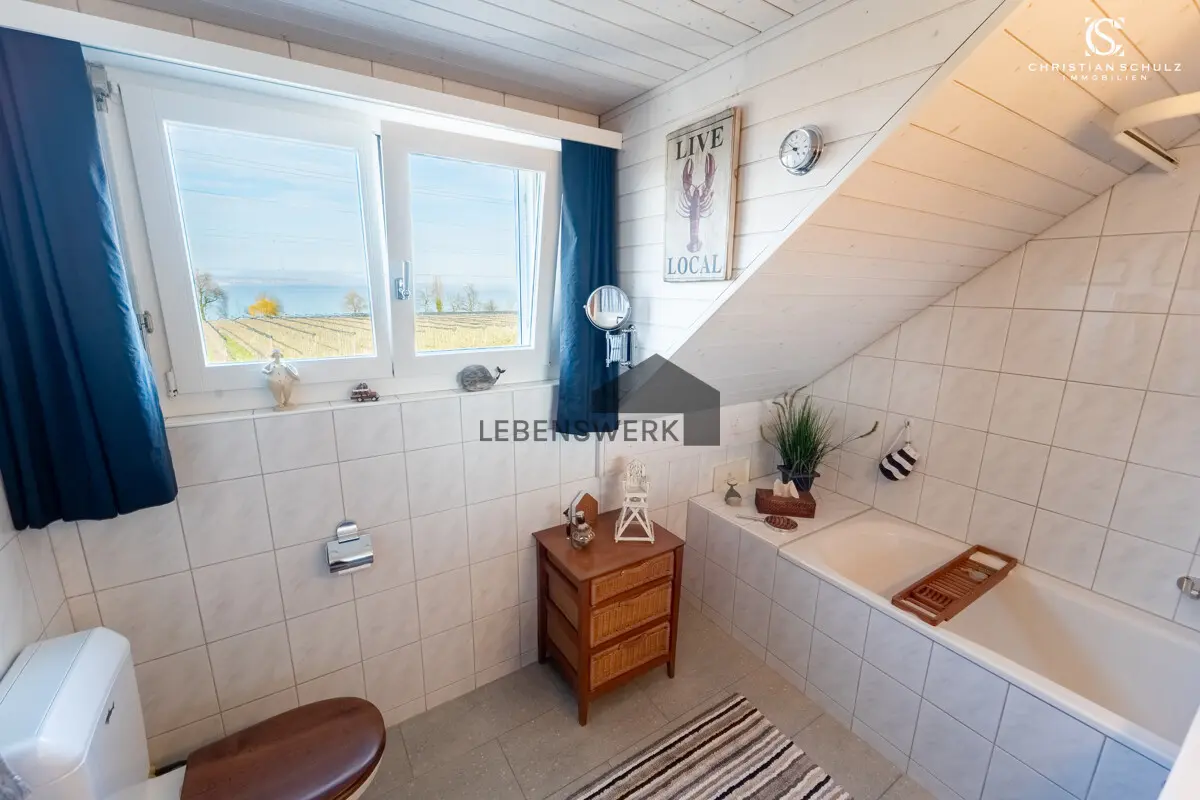 Helles Badezimmer mit Badewanne und Seesicht.