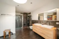 Luxuriöses Spa-Ambiente im Wellnessbad mit erfrischender Dusche versehen mit Rundumdüsen und Regendusche