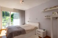 Schlafzimmer mit Blick in den Garten und Mückenschutzgitter