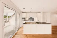 Moderne Küche mit Kochinsel und direktem Zugang zur gedeckten Loggia