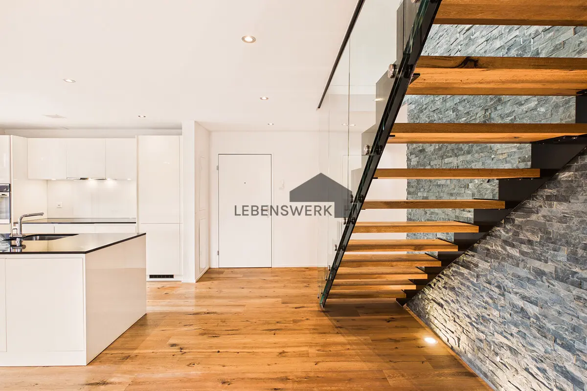 Architektonisches Highlight. Freitragende Holztreppe mit Glasgeländer und Natursteinwand