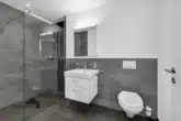 Das moderne ensuite Duschbad - Perfekte Attikawohnung mit grosser Terrasse und Pool (Alpenkettensicht) – Whg. Nr. 09